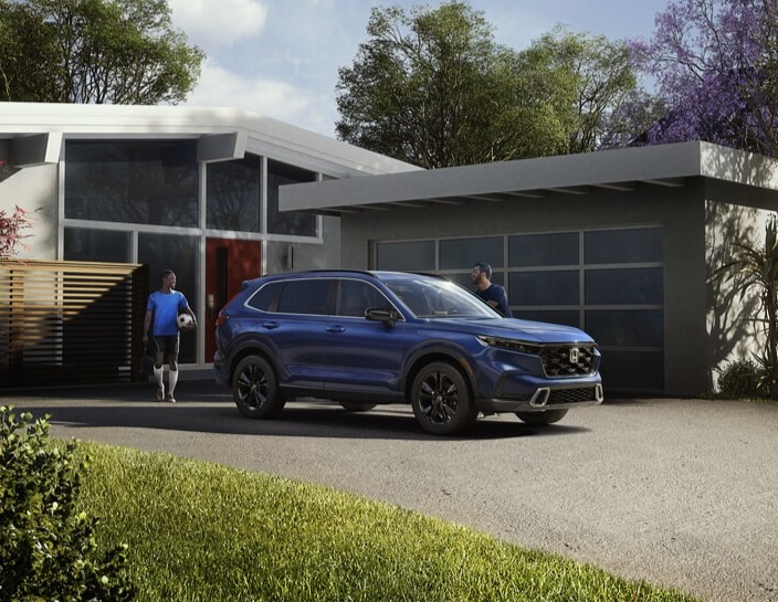 Blue Honda CR-V Hybrid parked by a house
