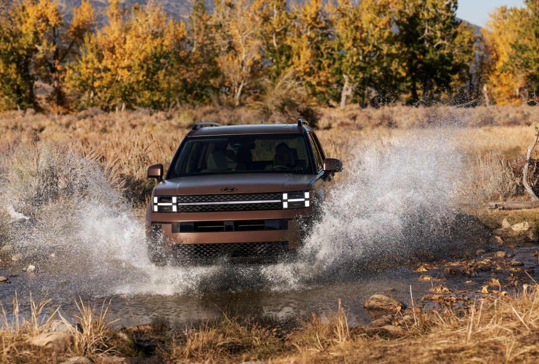 Brown Hyundai Santa Fe driving through water