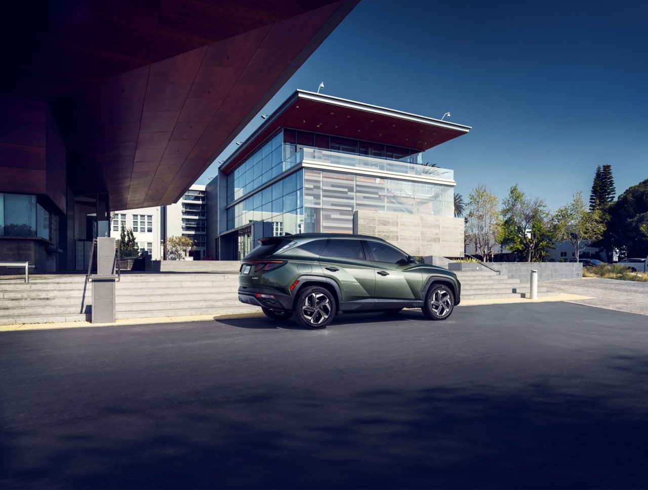 Blue Hyundai Tucson Hybrid parked by a building