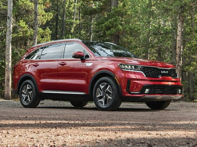 Red Kia Sorento Hybrid parked in the woods
