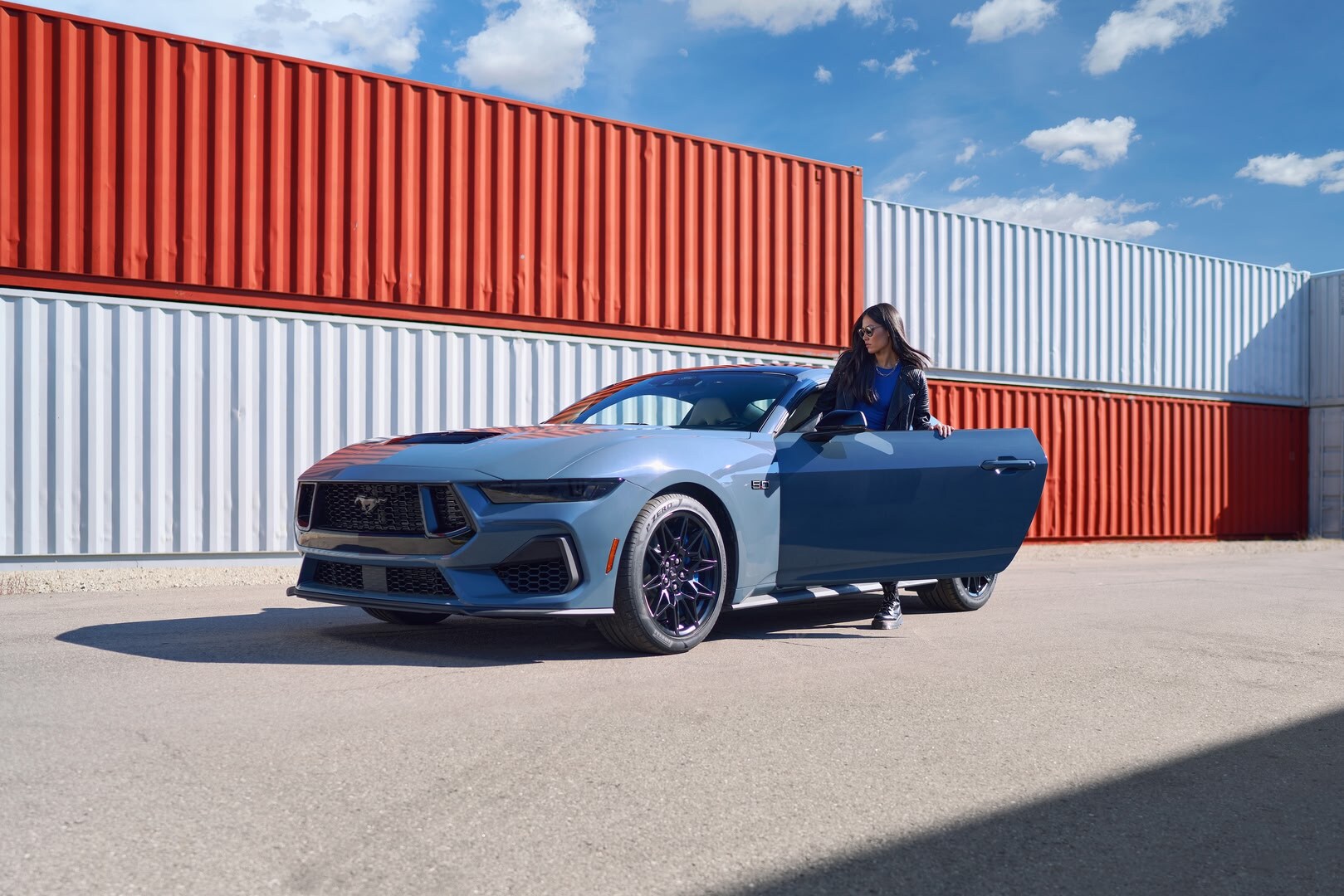 Woman getting into blue Ford Mustang