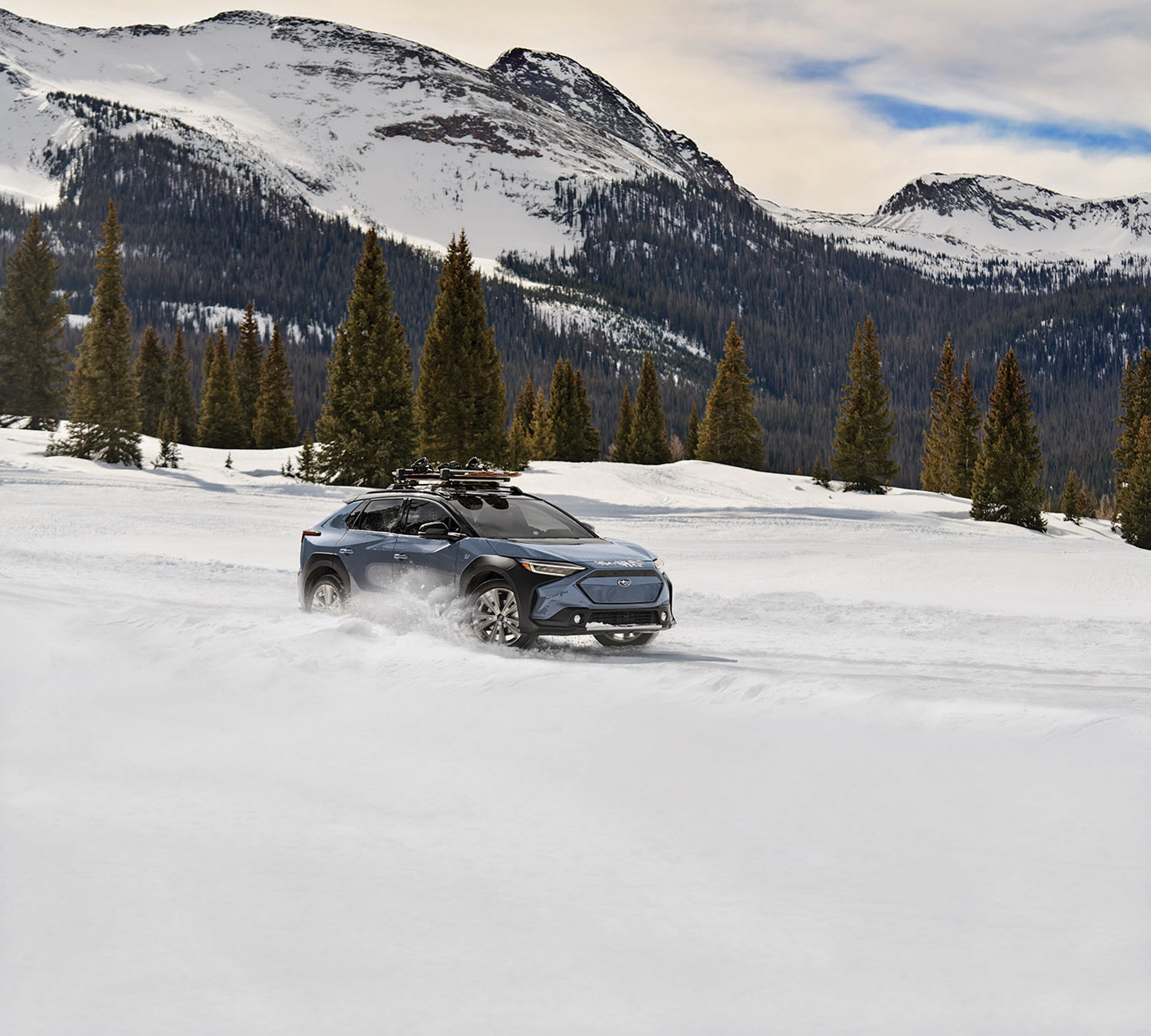 Subaru Solterra with ski rack on snow covered road