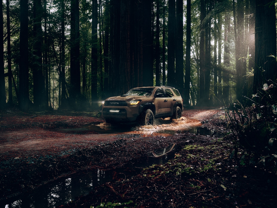  2026 Toyota 4Runner driving on muddy trail in woods