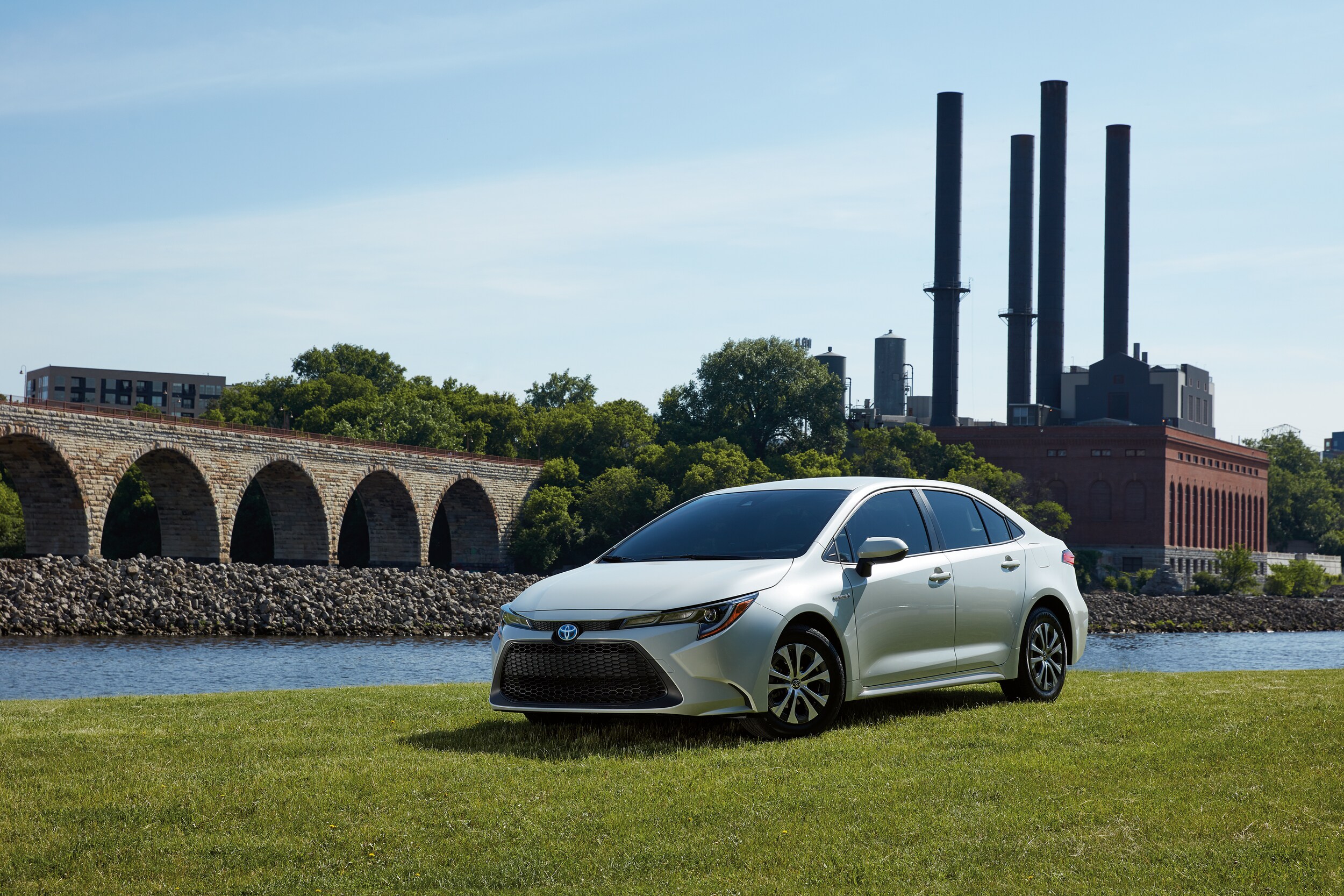 White Toyota Corolla Hybrid by a river