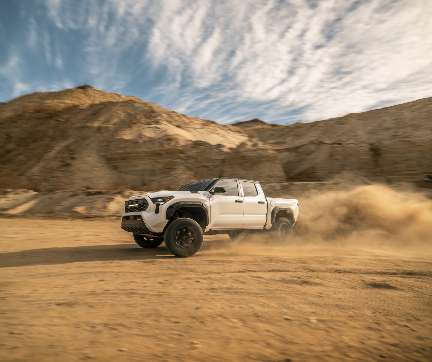 Toyota Tacoma Hybrid driving on dirt trail