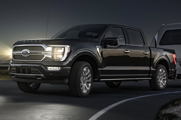 ford pulling a trailer at night on the road