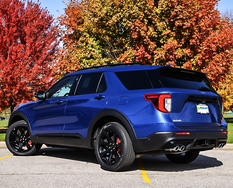 2020 Blue Ford Explorer rear exterior parked in a parking lot in front of trees