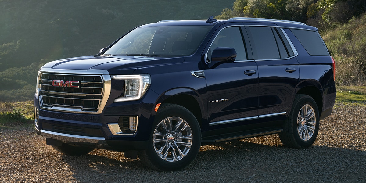 GMC Yukon SLT parked in gravel overlooking mountains