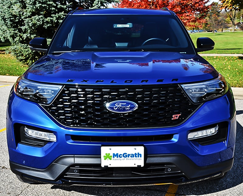 2020 Blue Ford Explorer front grille parked in front of trees