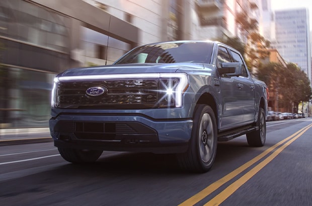F150 Lightning driving down a city block