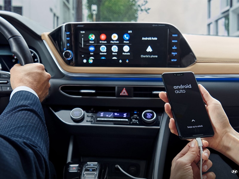 2020 Hyundai Sonata interior infotainment center and a hand holding an phone using android auto