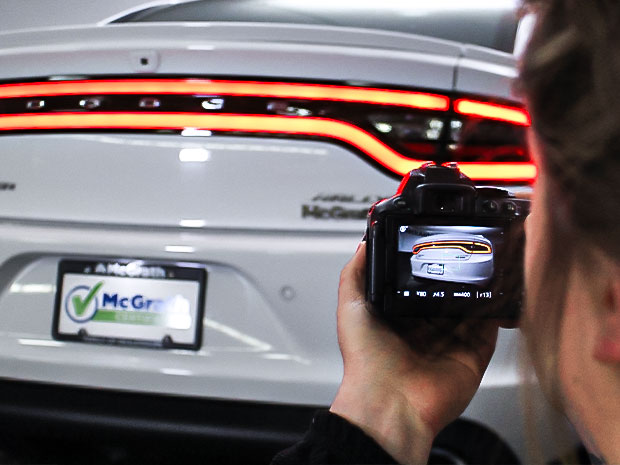 Woman taking photo of Dodge Charger rear trunk
