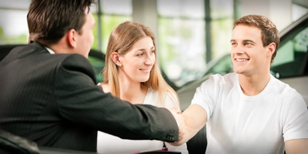 Car salesman shaking hands