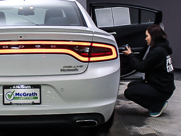 Young woman taking photo of Dodge Charger interior