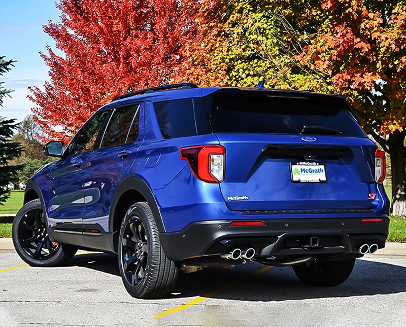 2020 Blue Ford Explorer rear exterior parked in a parking lot in front of trees