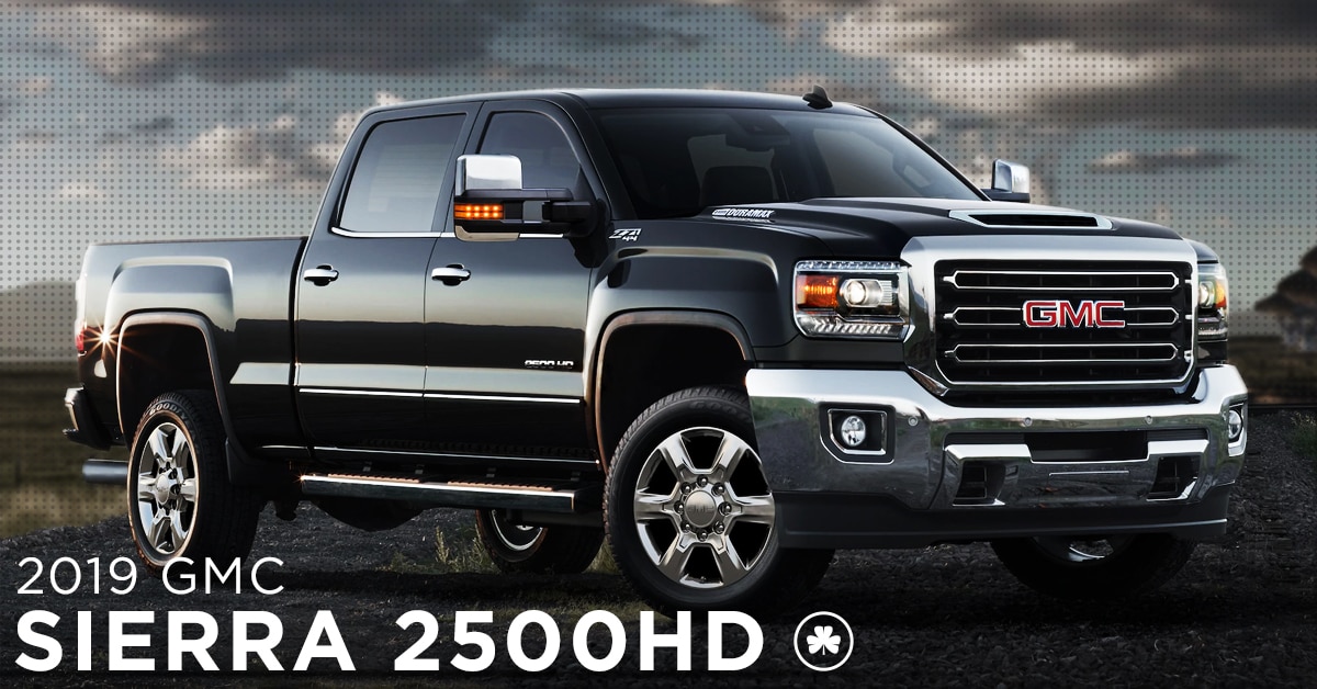 2019 Black GMC Sierra 2500HD parked on a gravel road in the open field
