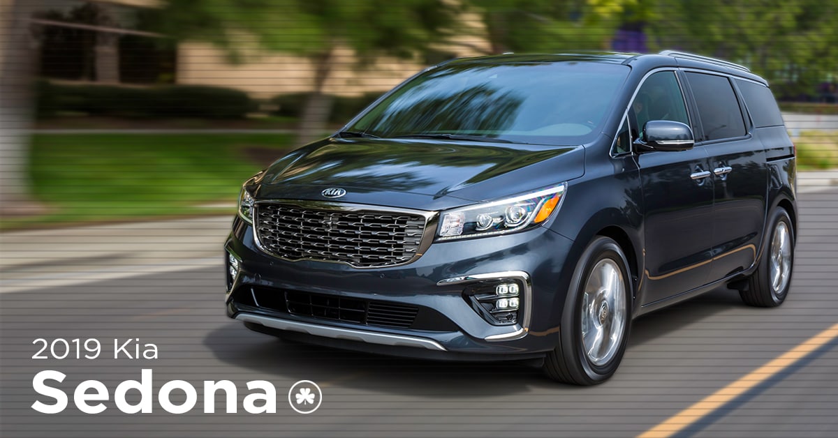 2019 silver Kia Sedona driving down the street
