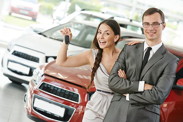 Woman holding keys and salesman