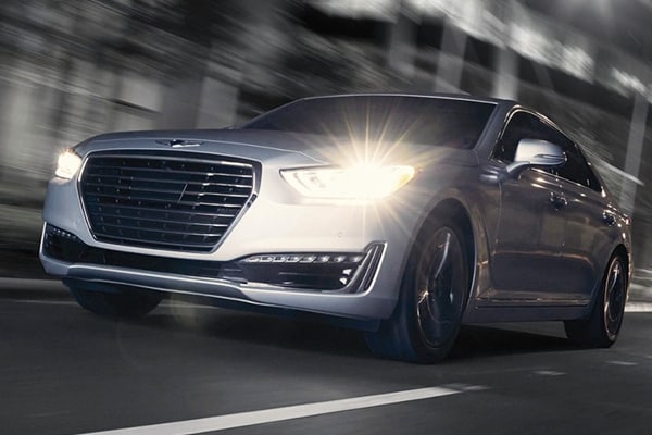 2019 Genesis G90 driving down the road with lights on