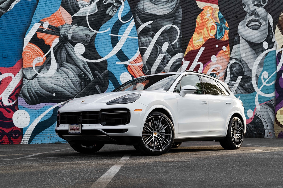 McKenna Kosmetics at McKenna Porsche A 2019 Porsche Cayenne Turbo parked in front of a mural on the side of a brick building.