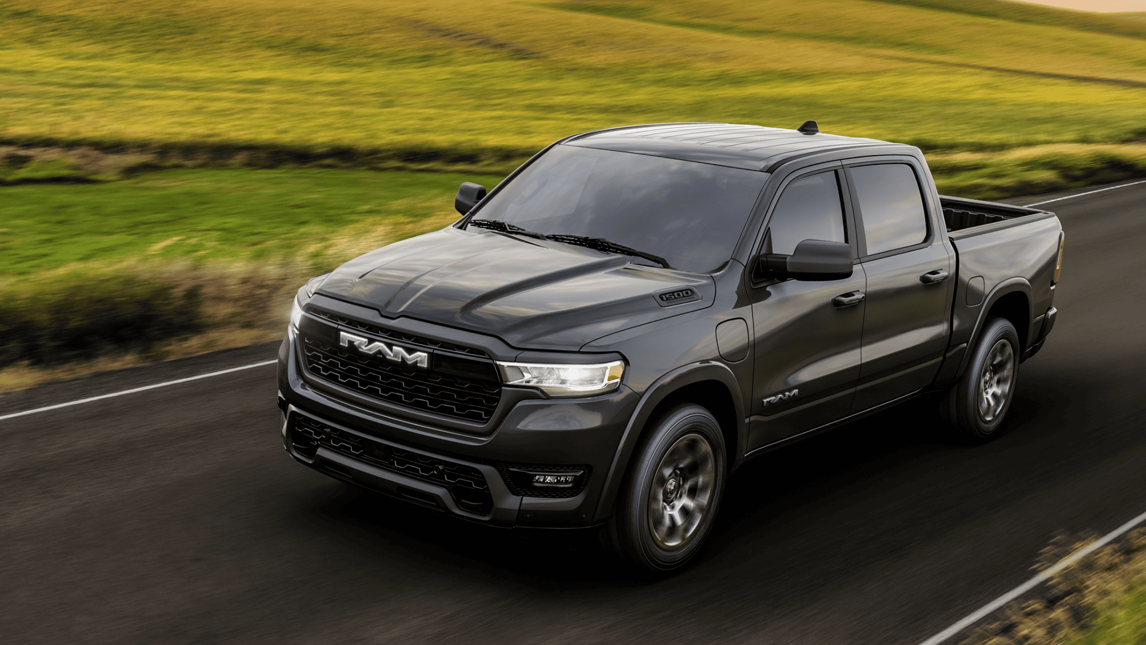 Gray Ram 1500 pickup truck on country road, exterior front view, rolling landscape