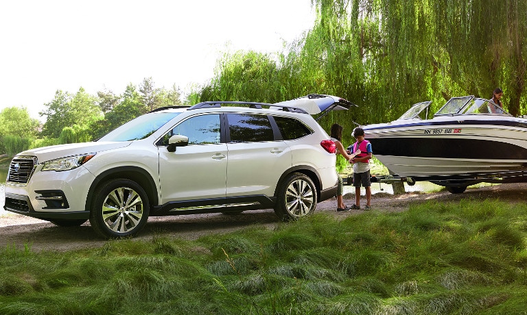 White Subaru Ascent towing boat