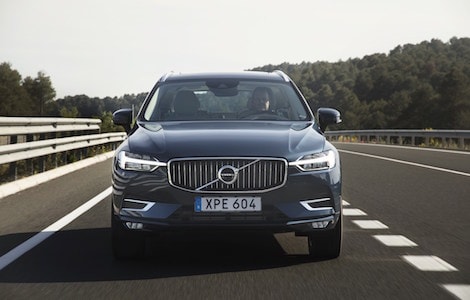 Volvo XC60 driving down a highway A blue Volvo XC60 driving down an open highway