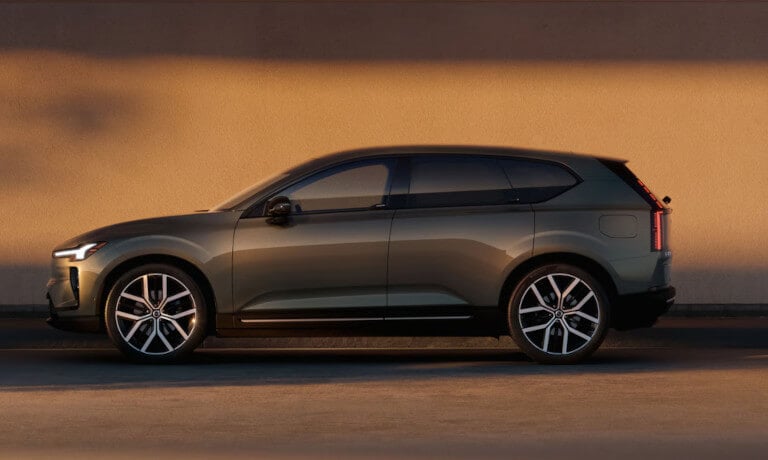 2027 Volvo EX60 side view by a wall