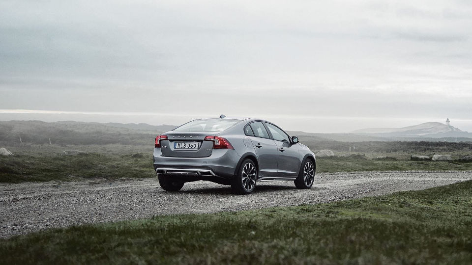 A silver 2018 Volvo S60 driving away