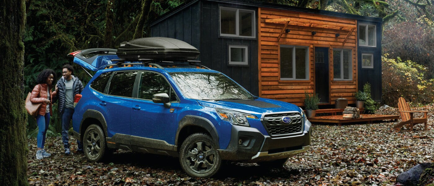 2022 Subaru Crosstrek parked in front of cabin in the woods