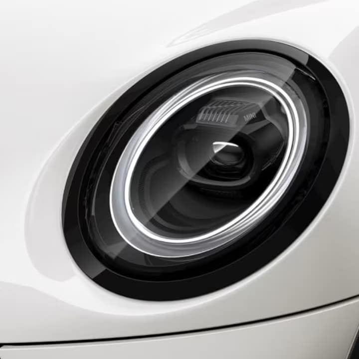 Closeup view of a LED headlight on a white MINI vehicle.