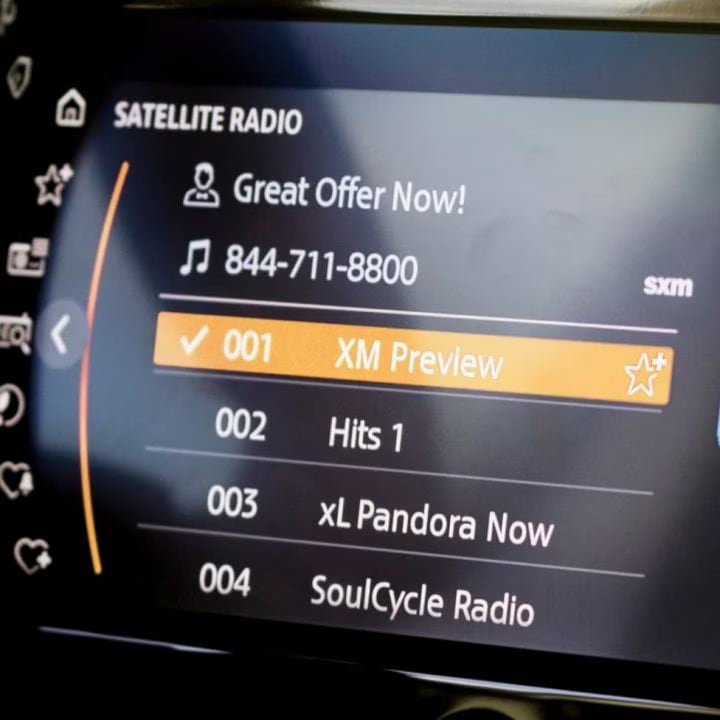 Closeup view of the touchscreen media display in a MINI vehicle with SiriusXM radio appearing on its screen.