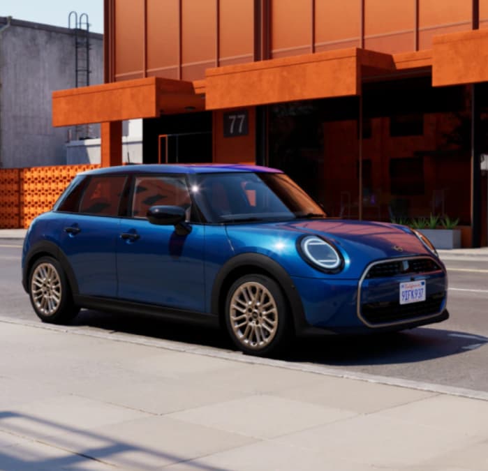 The MINI Cooper S 4 Door parked in front of an orange building.