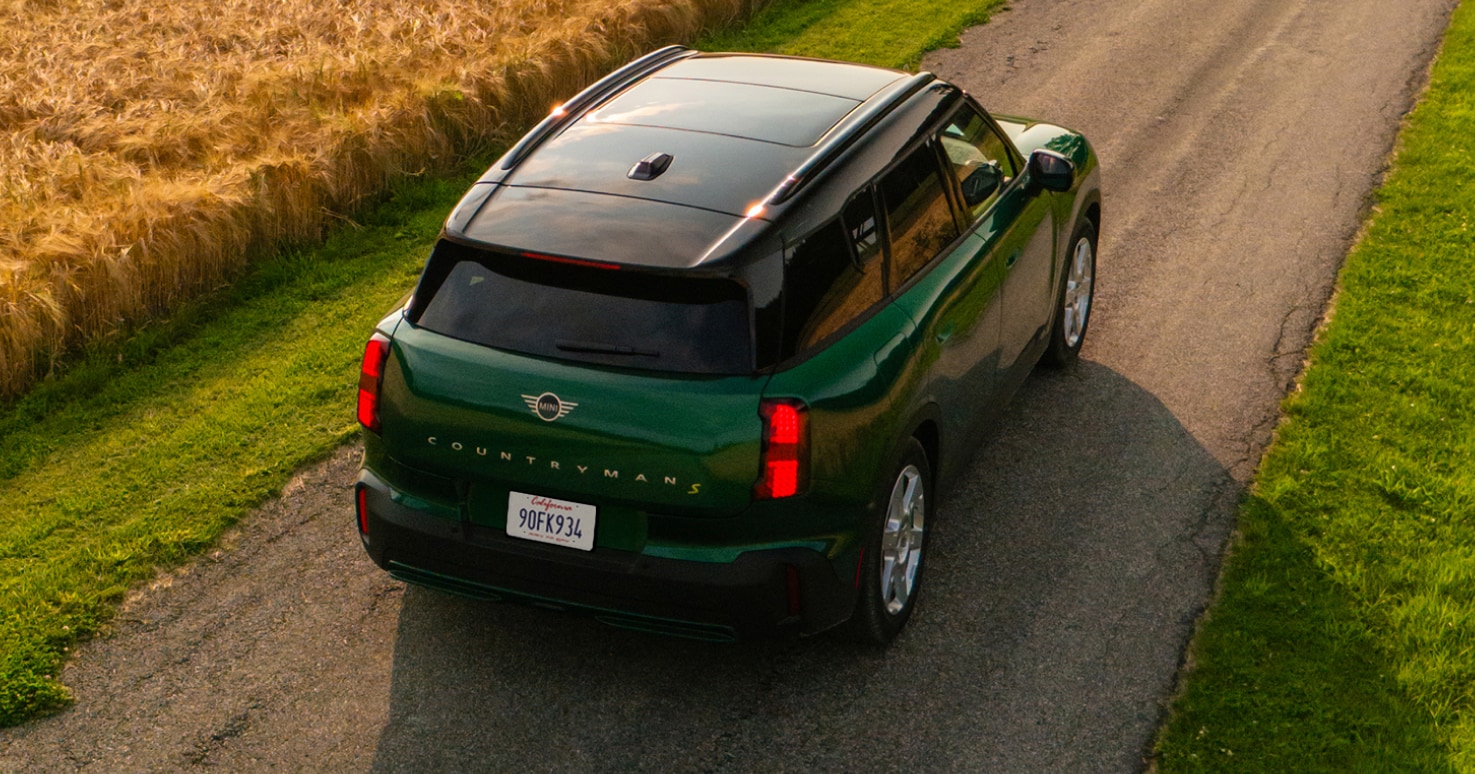Bird’s-eye view of the MINI Countryman SE ALL4 driving down a road.