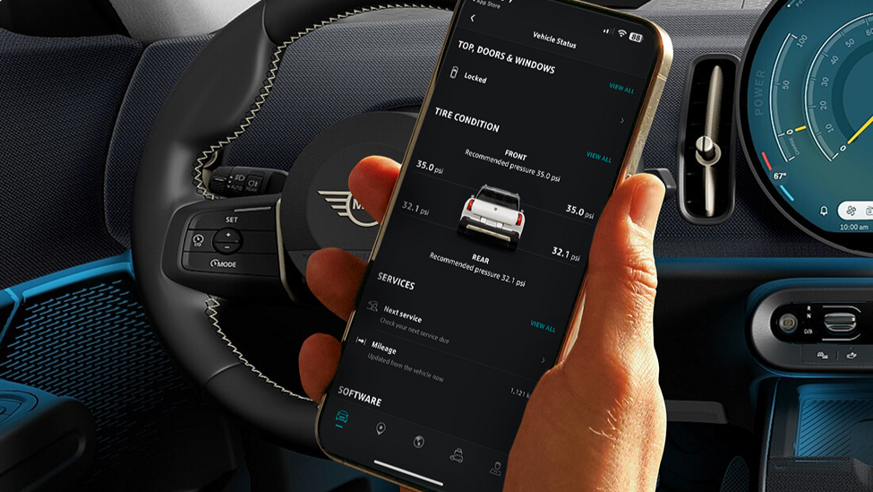 A hand holding up a phone open to the MINI App.