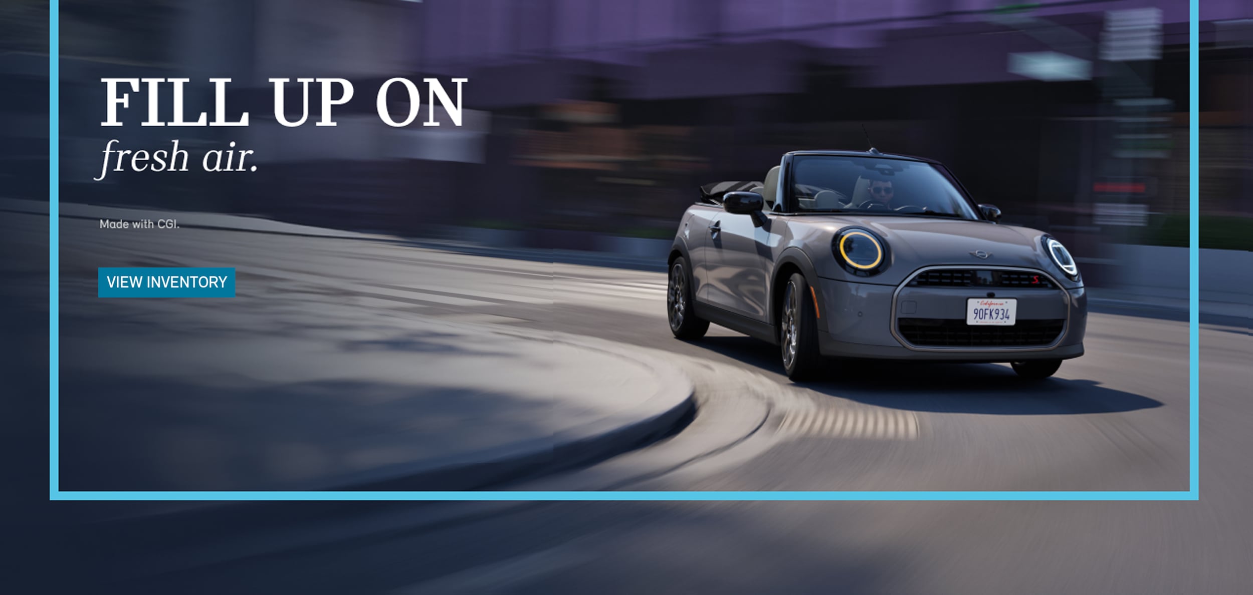 Front view of a MINI Cooper Convertible driving on a city street with a blurred background.