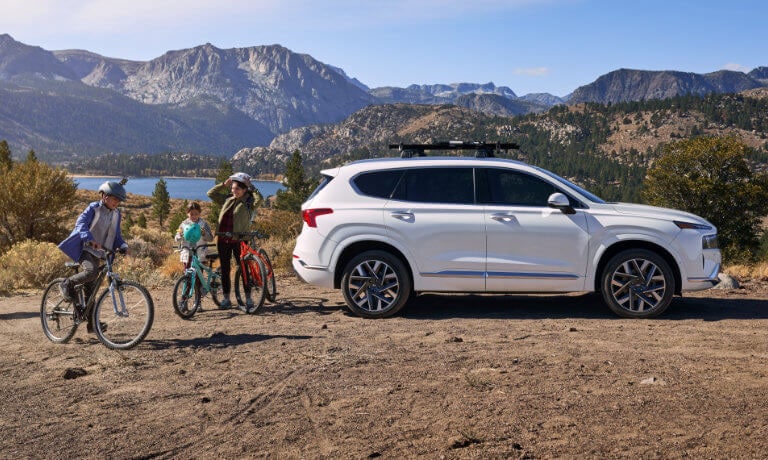 Family getting ready to bike next to 2021 Hyundai Santa Fe parked in the Mountains