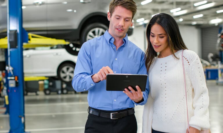 Hyundai service tech with customer looking at tablet
