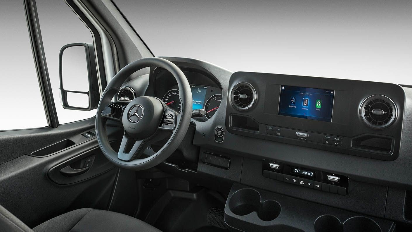 Interior shot of a Mercedes-Benz Sprinter Van showing the steering wheel and console