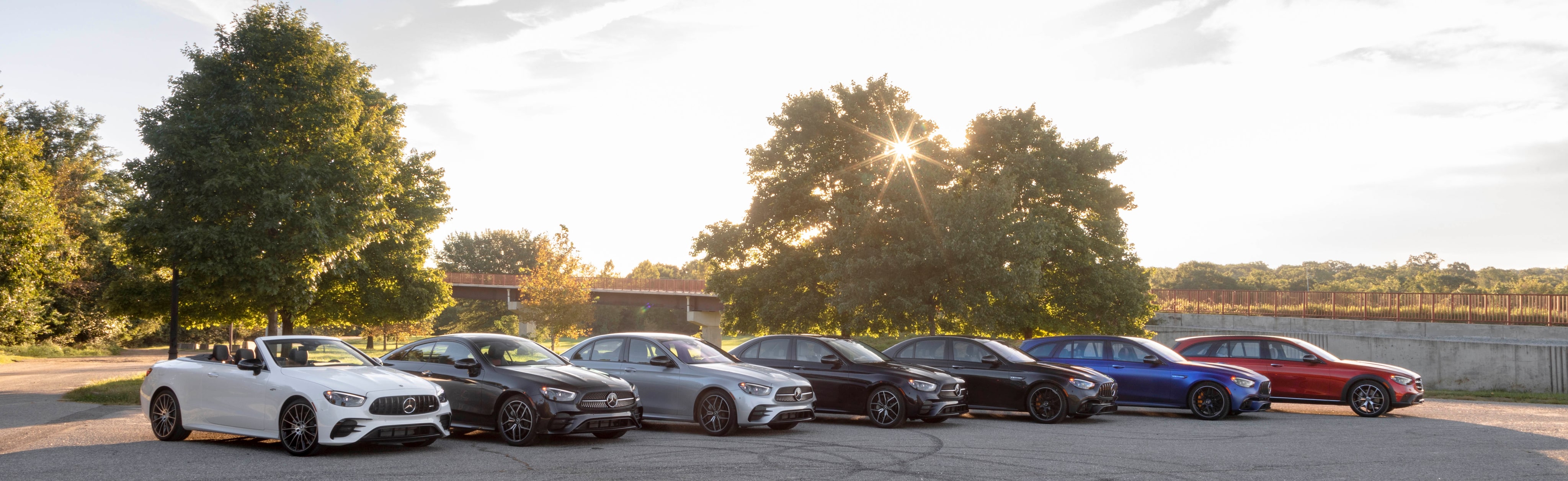 Seven Mercedes-Benz vehicles parked
alongside each other outside on a sunny day