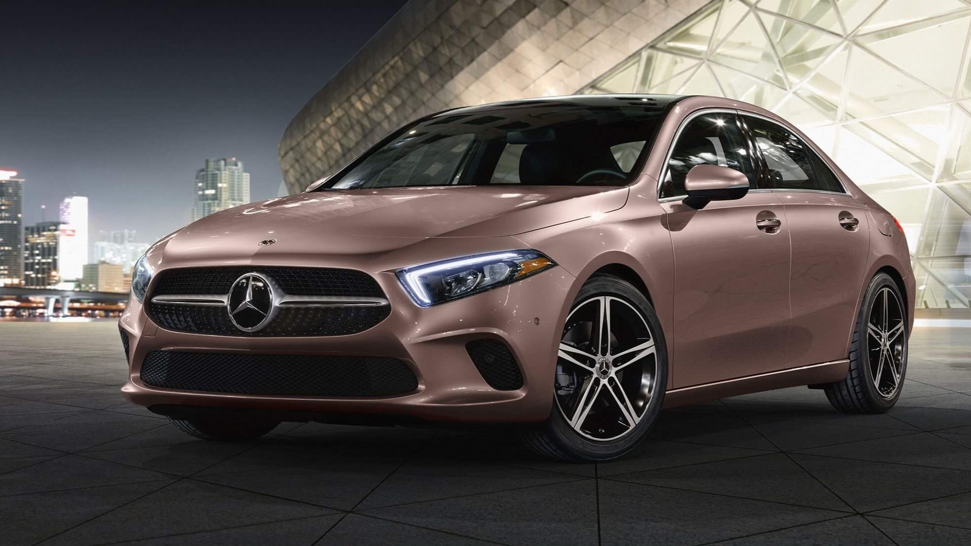 Outdoor evening shot of a Mercedes-Benz sedan parked outside a building