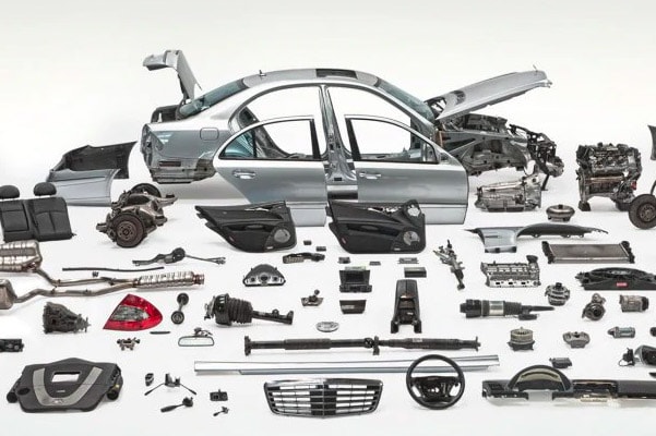 mercedes benz vehicle parts scattered in a white room studio