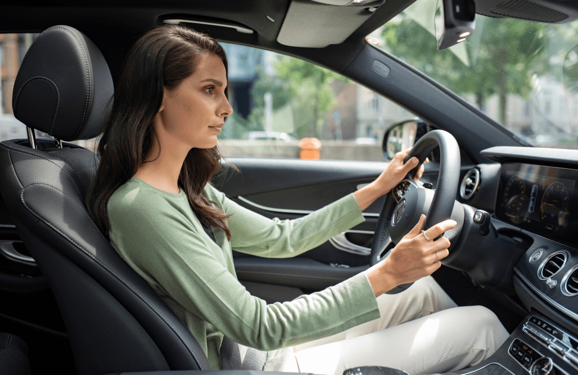 Woman driving a Mercedes-Benz using safety features