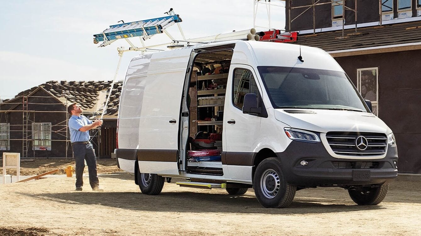 Learn about the specs, configurations, and color options of the Mercedes-Benz Sprinter Cargo Van Exterior shot of a Mercedes-Benz Sprinter Cargo Van at a construction site of a house
