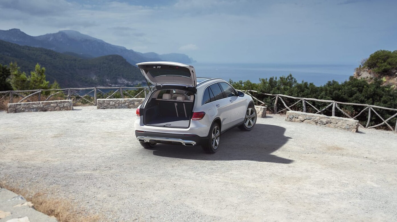 A white 2022 Mercedes-Benz GLC sits parked at an overlook of the ocean with the rear hatch open