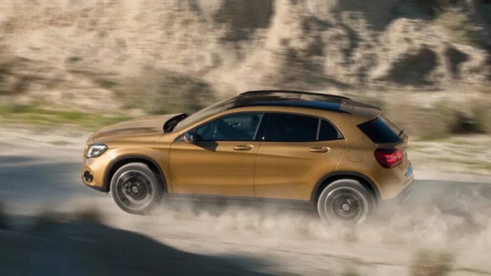 A Mercedes-Benz SUV driving on a dirt road