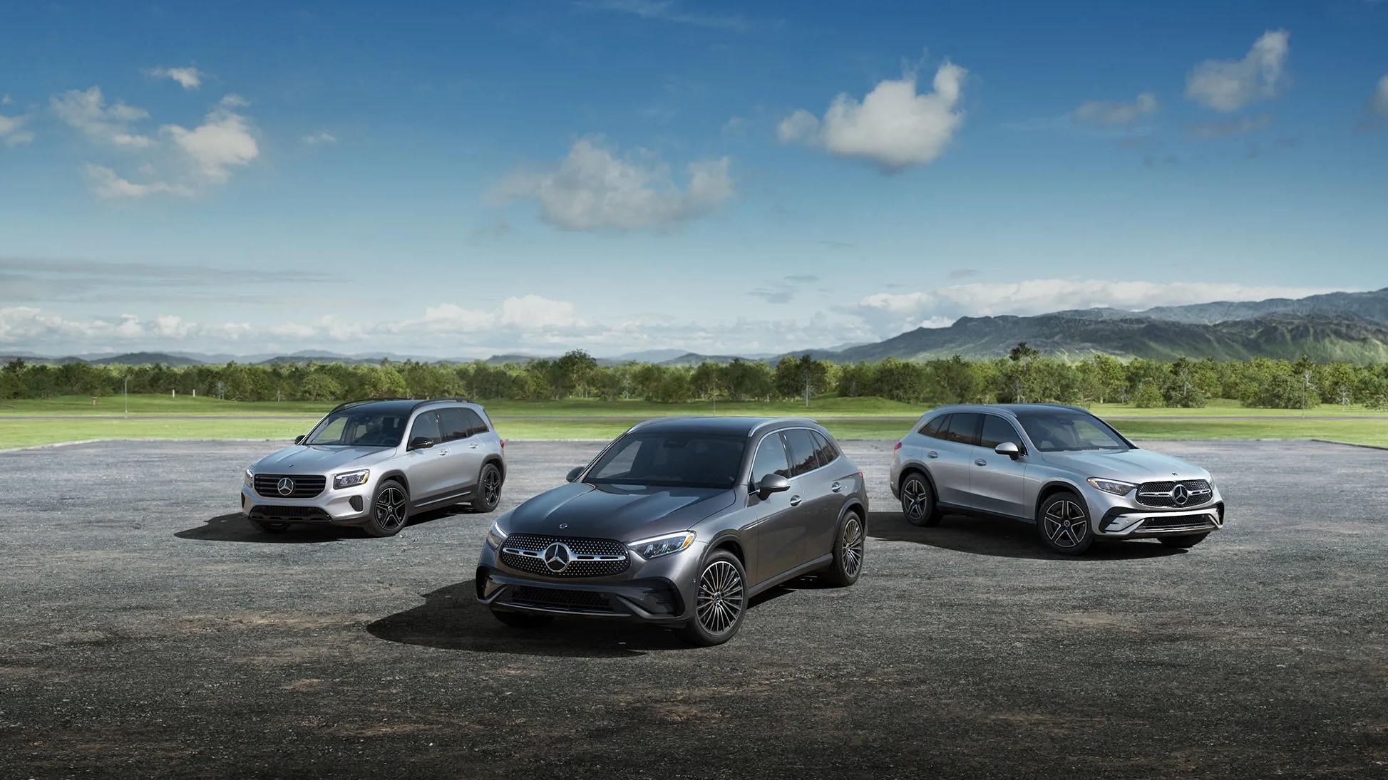 A lineup of three Mercedes-Benz SUVs parked outside in the sun