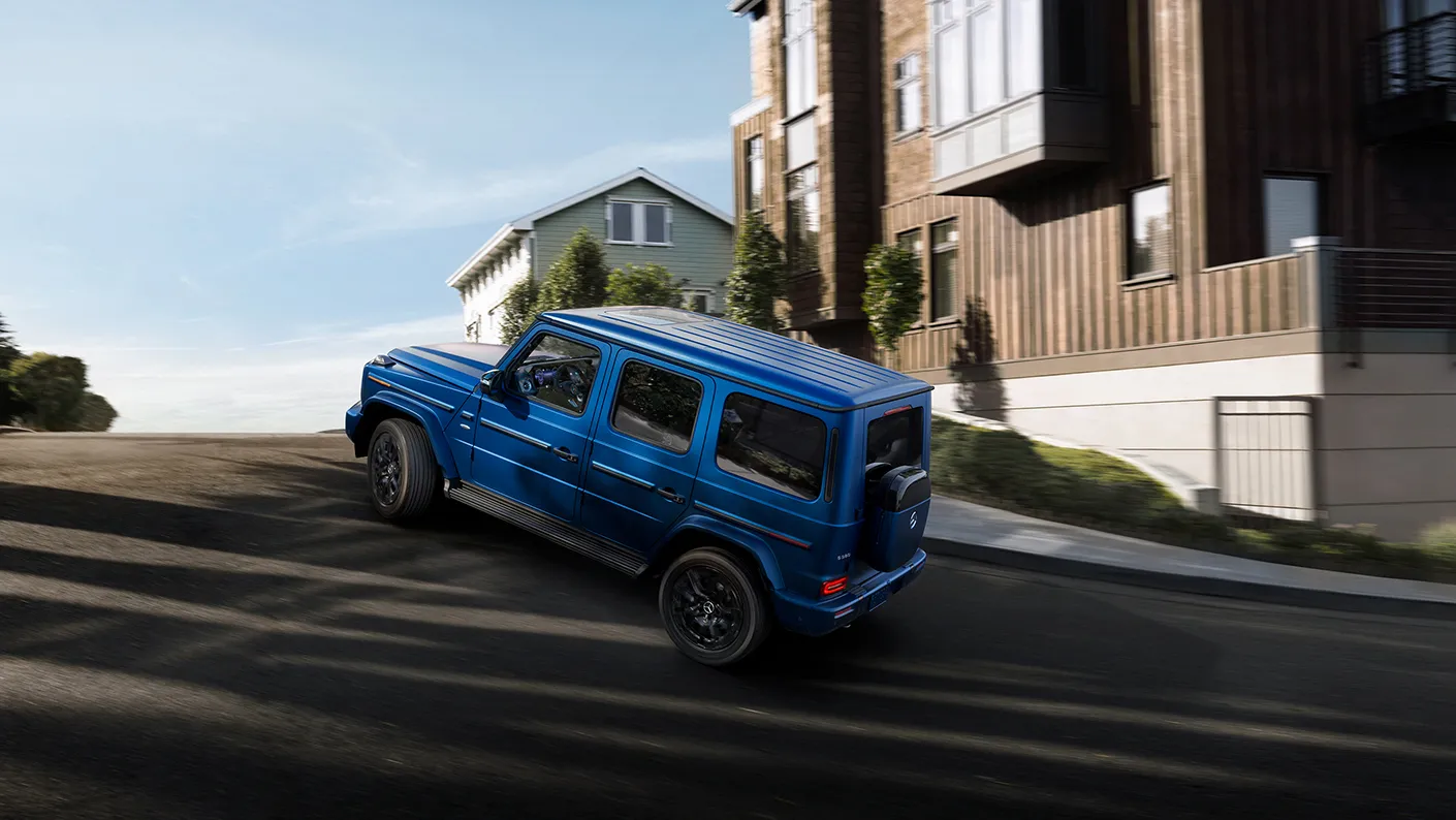 Rendered image of a G-Class SUV driving a neighborhood uphill
