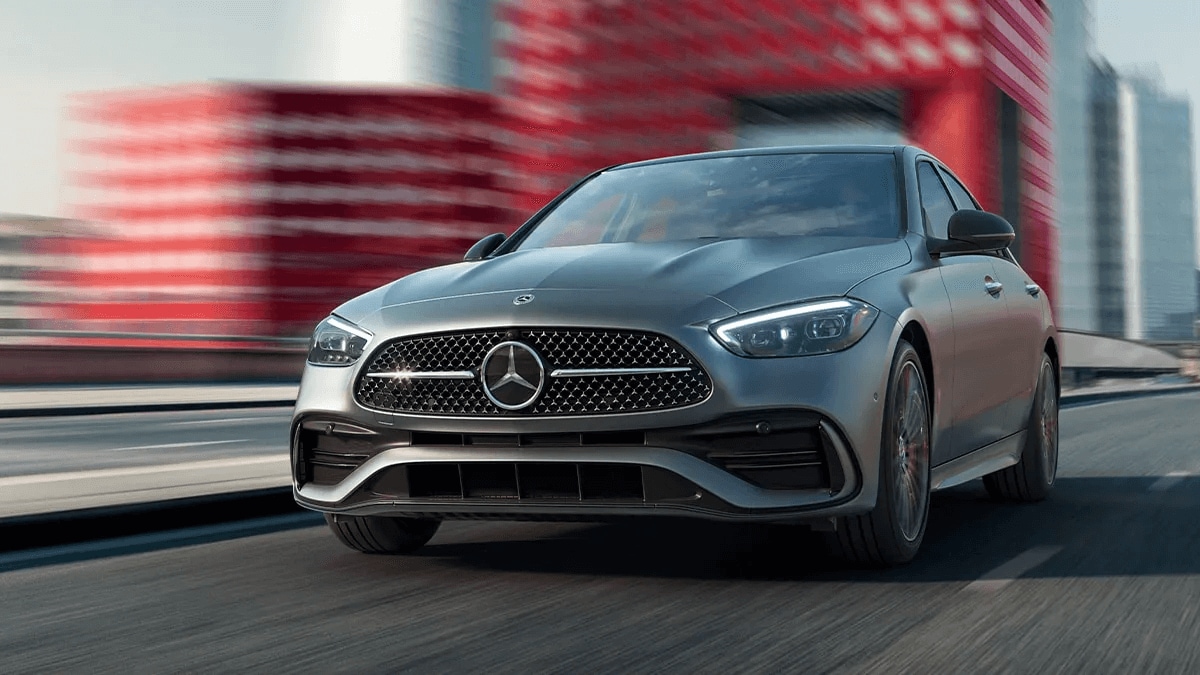 Exterior shot of a Mercedes-Benz C-Class sedan driving down a road
