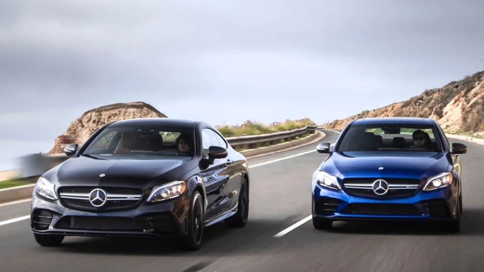A Pair of Mercedes-Benz AMG sedans driving on the road